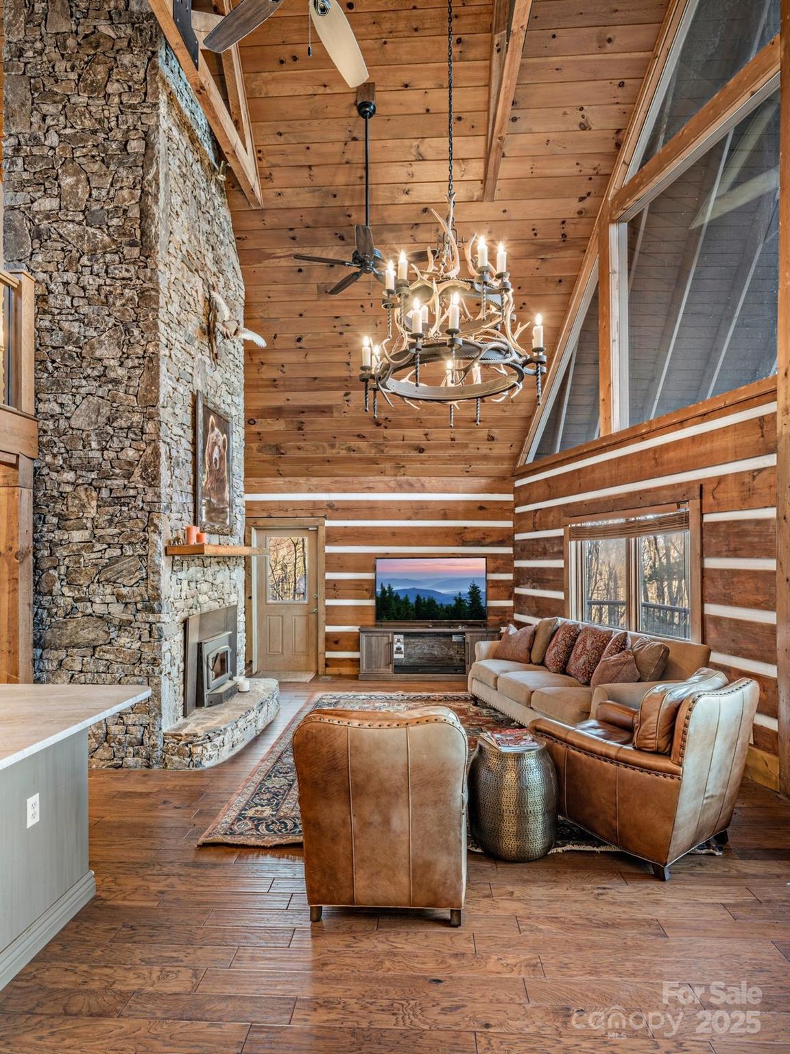 135 Grouse Point Road Maggie Valley, NC 28751 - Photo 17 of 48 a living room with furniture and a chandelier