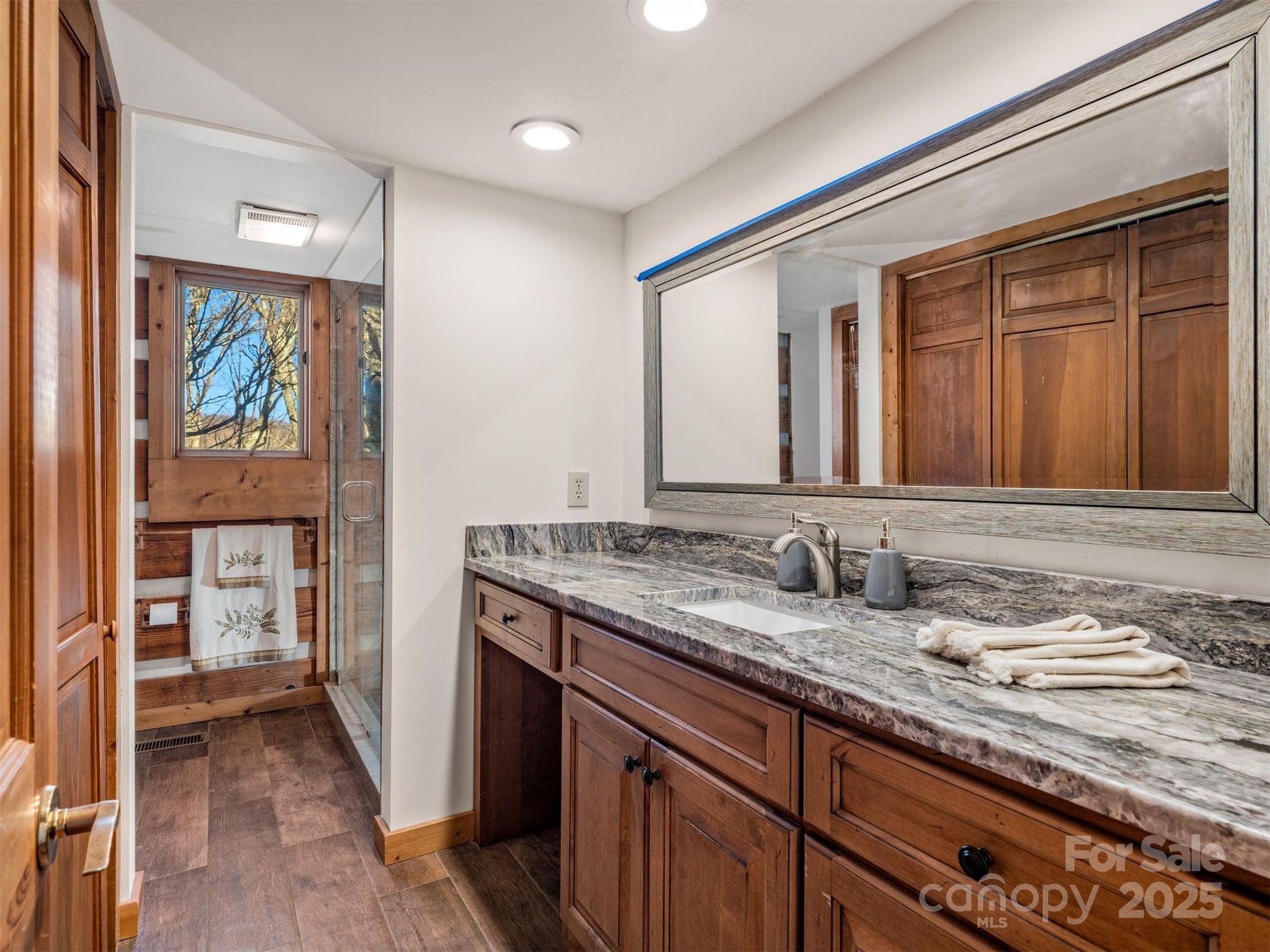 135 Grouse Point Road Maggie Valley, NC 28751 - Photo 20 of 48 a bathroom with a granite countertop sink and a mirror