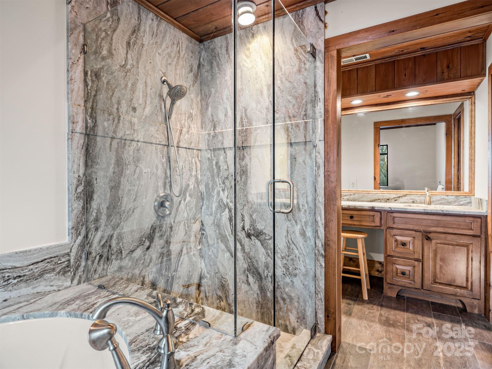 135 Grouse Point Road Maggie Valley, NC 28751 - Photo 26 of 48 a bathroom with a granite countertop sink and a mirror