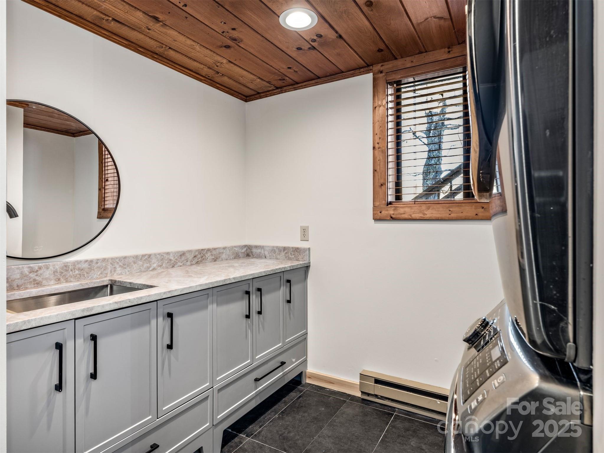 135 Grouse Point Road Maggie Valley, NC 28751 - Photo 36 of 48 a bathroom with a granite countertop sink a mirror and a vanity