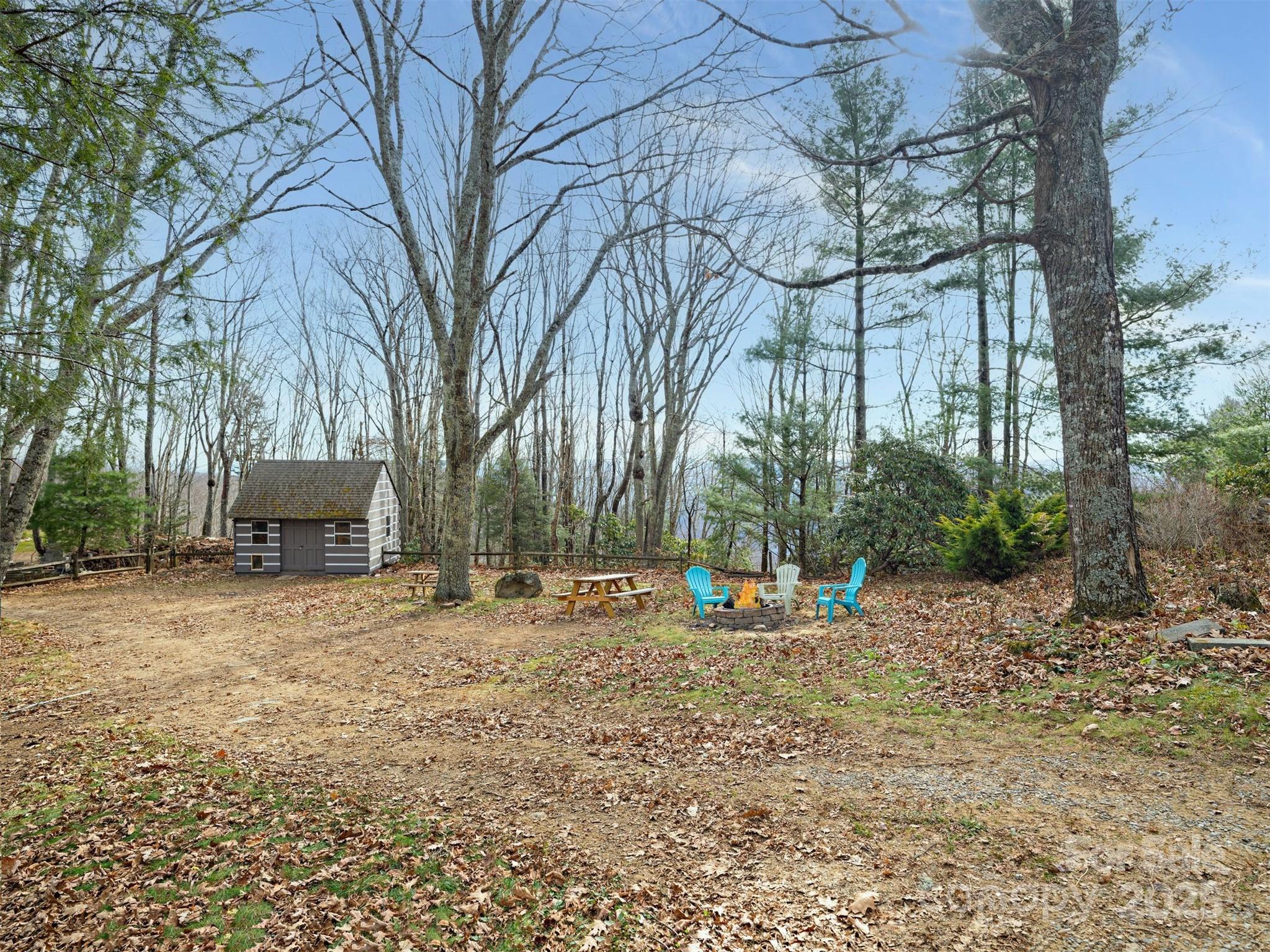 135 Grouse Point Road Maggie Valley, NC 28751 - Photo 38 of 48 a backyard of a house with table and chairs under an umbrella