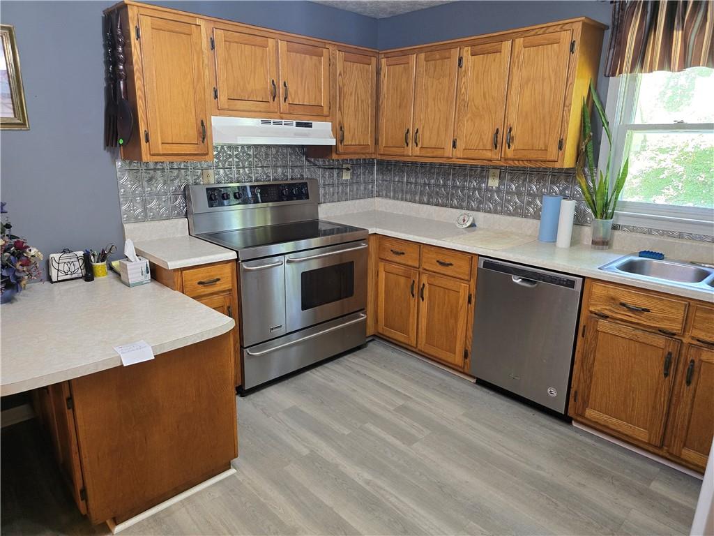 11953 Henderson Mountain Road Fairmount, GA 30139 - Photo 42 of 46 a kitchen with stainless steel appliances granite countertop a stove a sink and a refrigerator