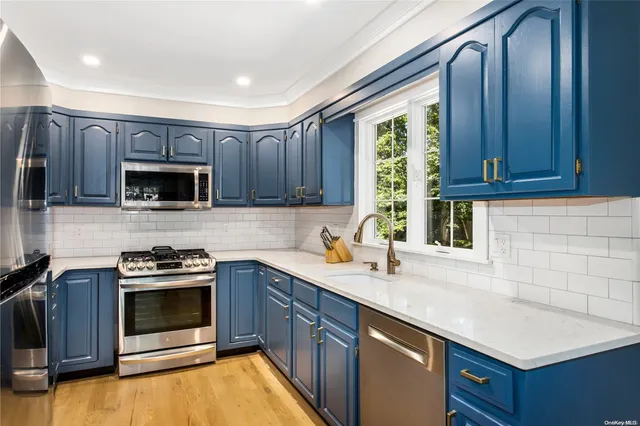 a kitchen with stainless steel appliances wooden cabinets stove and a sink