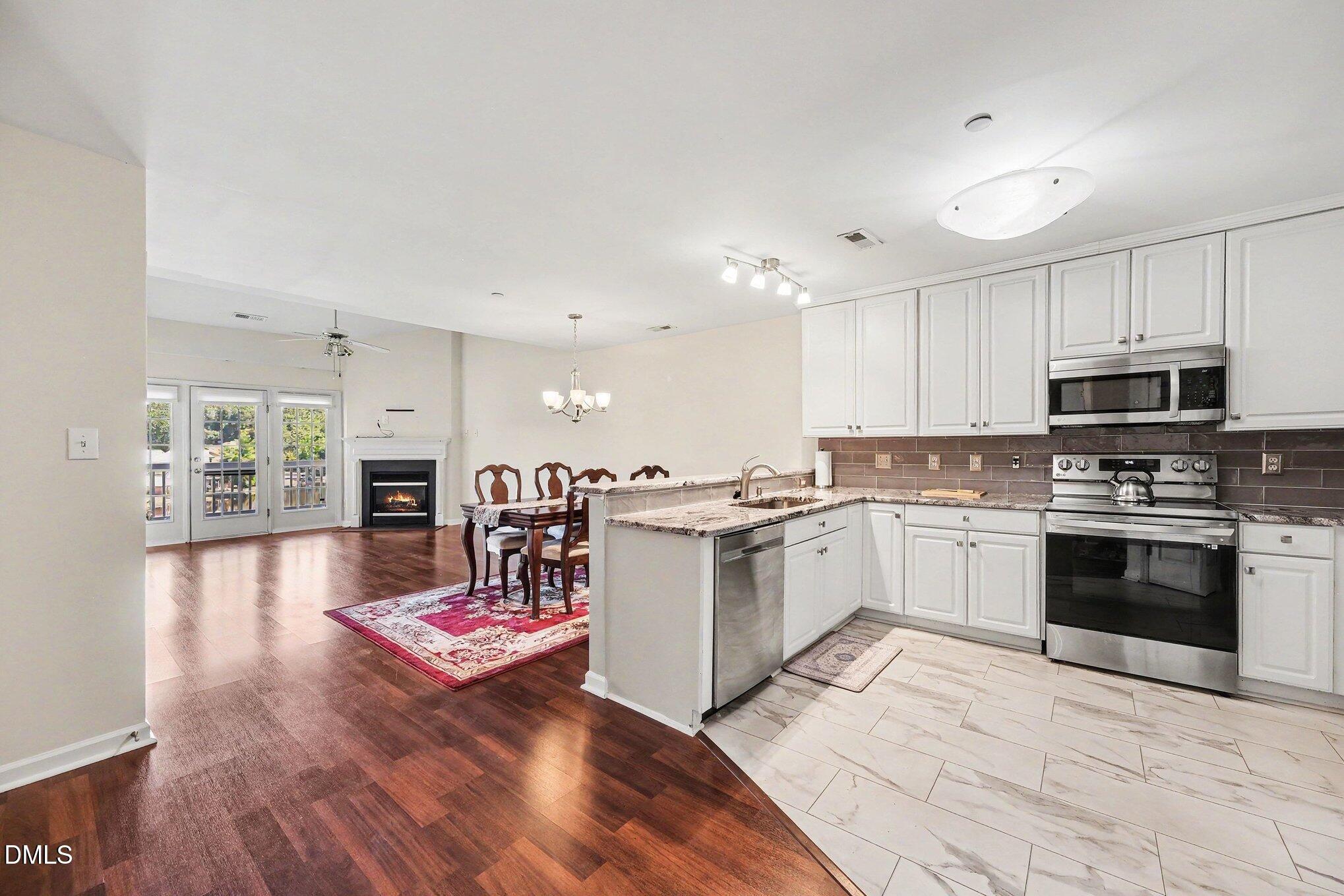 132 Springfork Drive Cary, NC 27513 - Photo 15 of 28 a kitchen with a refrigerator microwave and stove top oven