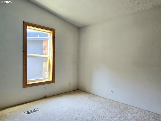 an empty room with windows and closet