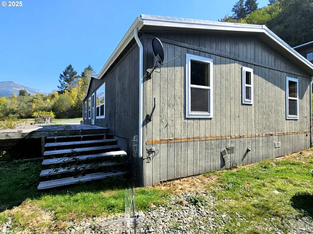 a view of a house with a small yard and wooden fence