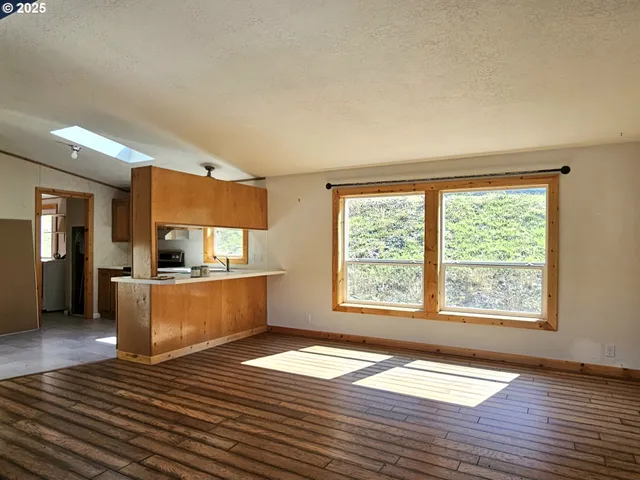 a kitchen with a wooden floor and a large window