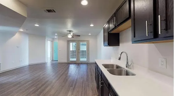 a kitchen with stainless steel appliances granite countertop a sink a stove and a wooden floors