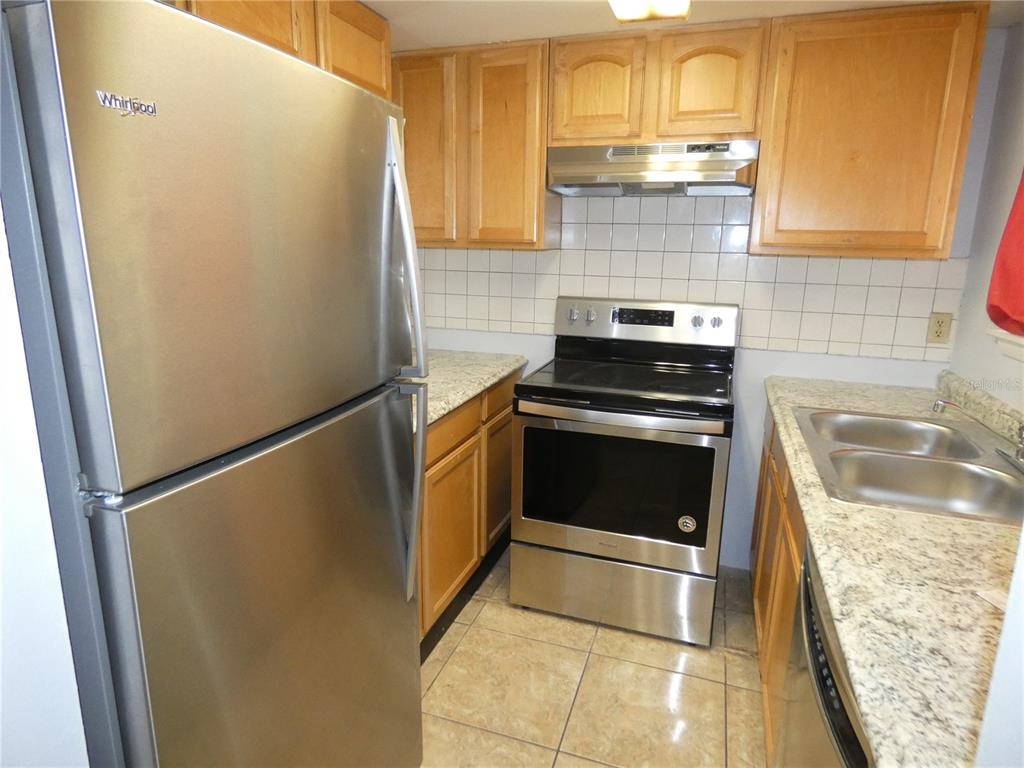 12080 Mendel Drive Orlando, FL 32826 - Photo 5 of 10 a kitchen with granite countertop a refrigerator and a stove