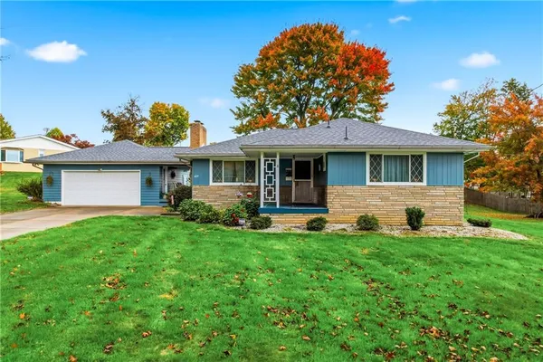a front view of a house with a yard and trees