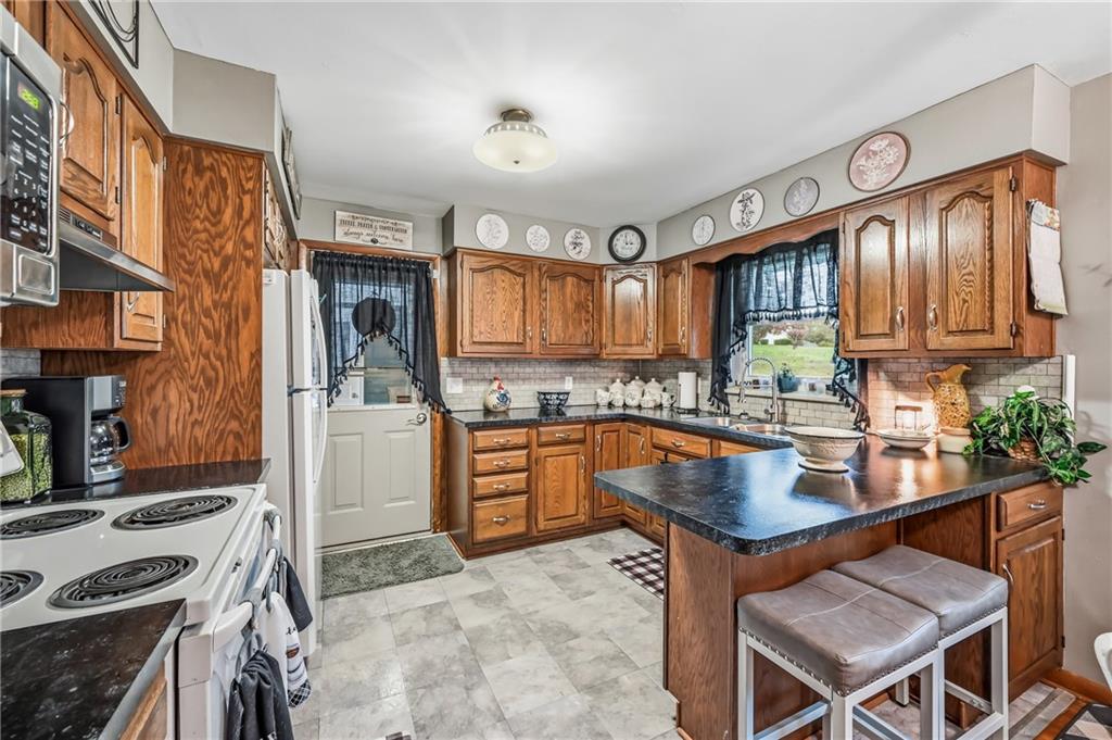 409 Patt Drive Farrell, PA 16121 - Photo 18 of 50 a kitchen with stainless steel appliances granite countertop a stove refrigerator sink and cabinets