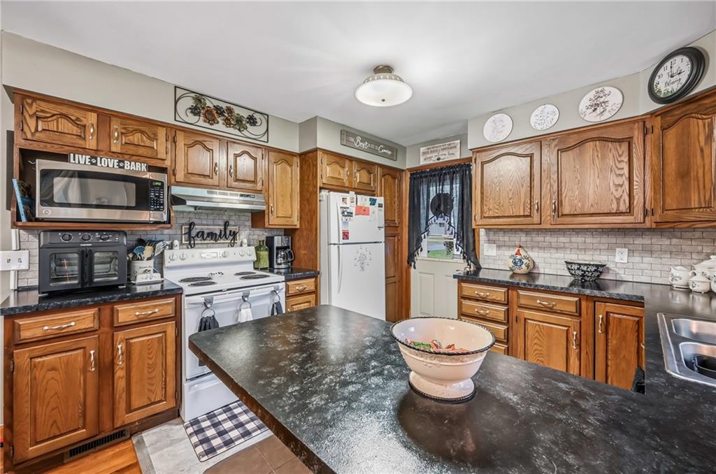 409 Patt Drive Farrell, PA 16121 - Photo 19 of 50 a kitchen with stainless steel appliances granite countertop a sink stove and cabinets