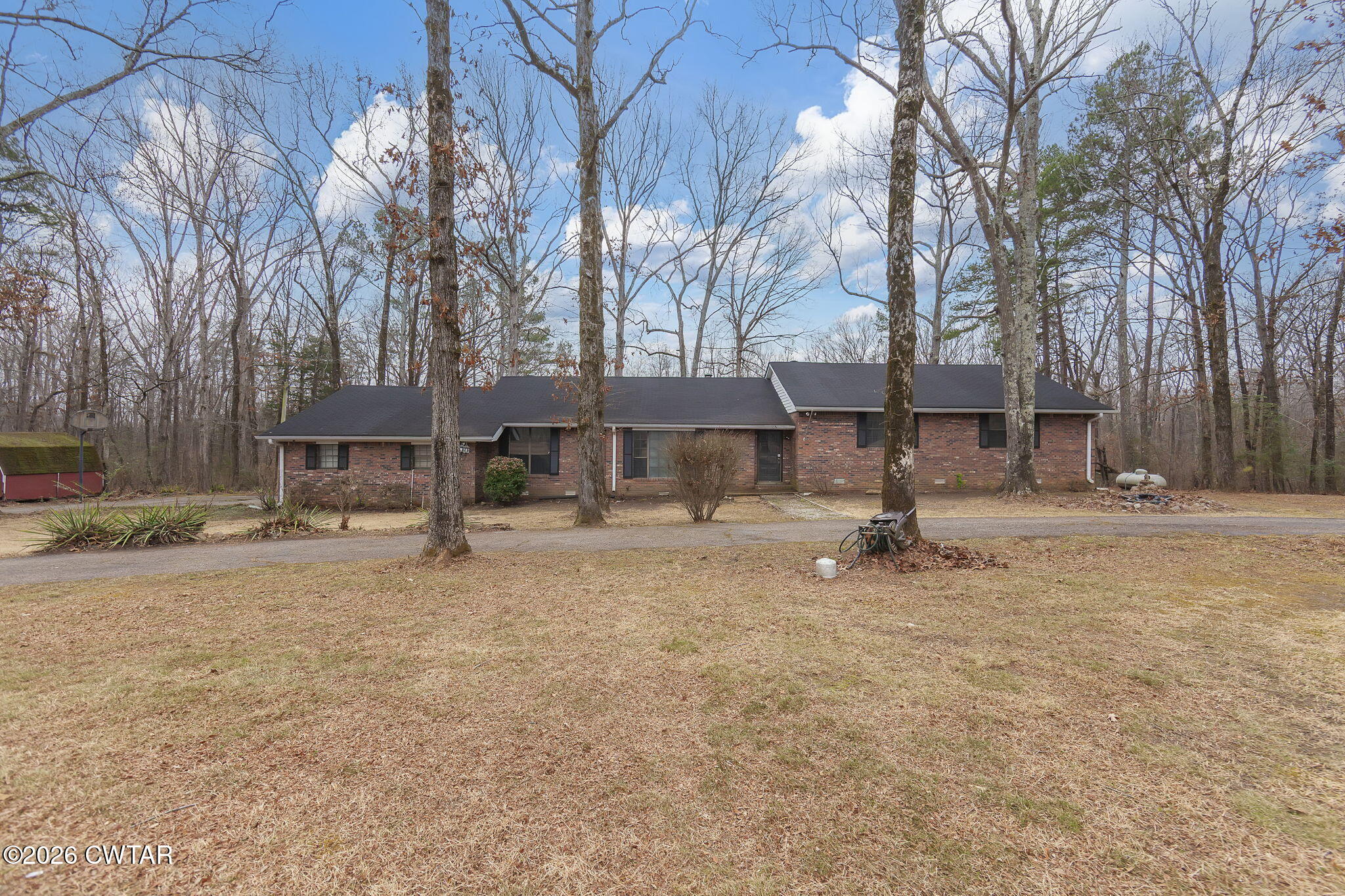 a front view of a house with a yard and trees