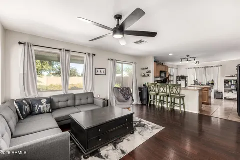 a living room with furniture kitchen view and a large window