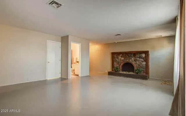 a view of an empty room with a fireplace and a window