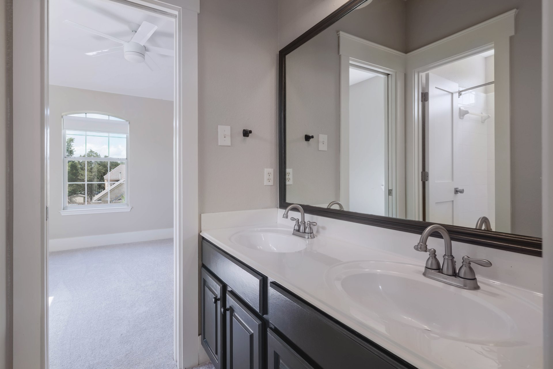 5512 Ballenton Lane Austin, TX 78739 - Photo 32 of 40 A well-appointed bathroom vanity with dual sinks, offering convenient access to a sun-filled bedroom.