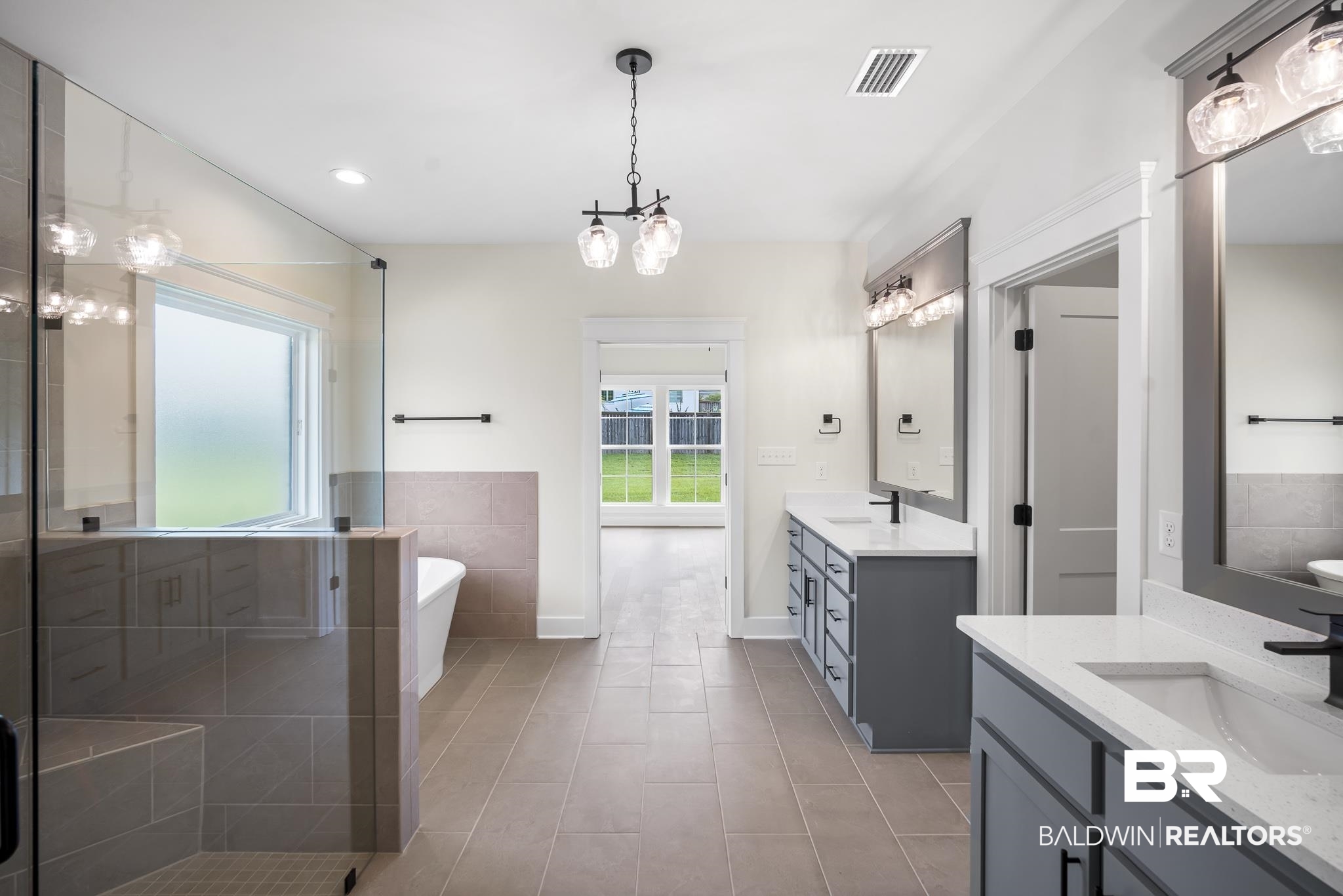 21826 Veranda Boulevard Fairhope, AL 36532 - Photo 20 of 42 Full bathroom with a stall shower, two vanities, a soaking tub, a chandelier, and recessed lighting