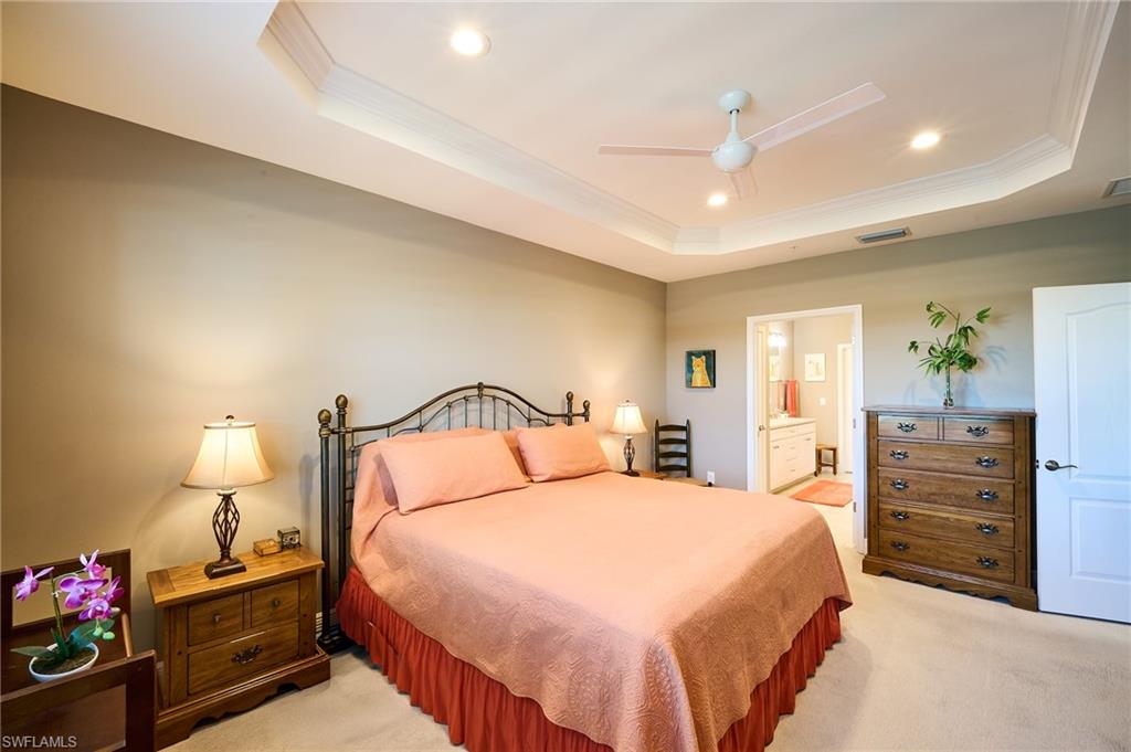2319 Sawyers Hill Road, Unit 701 Naples, FL 34120 - Photo 13 of 36 a bedroom with a bed and a lamp on dresser
