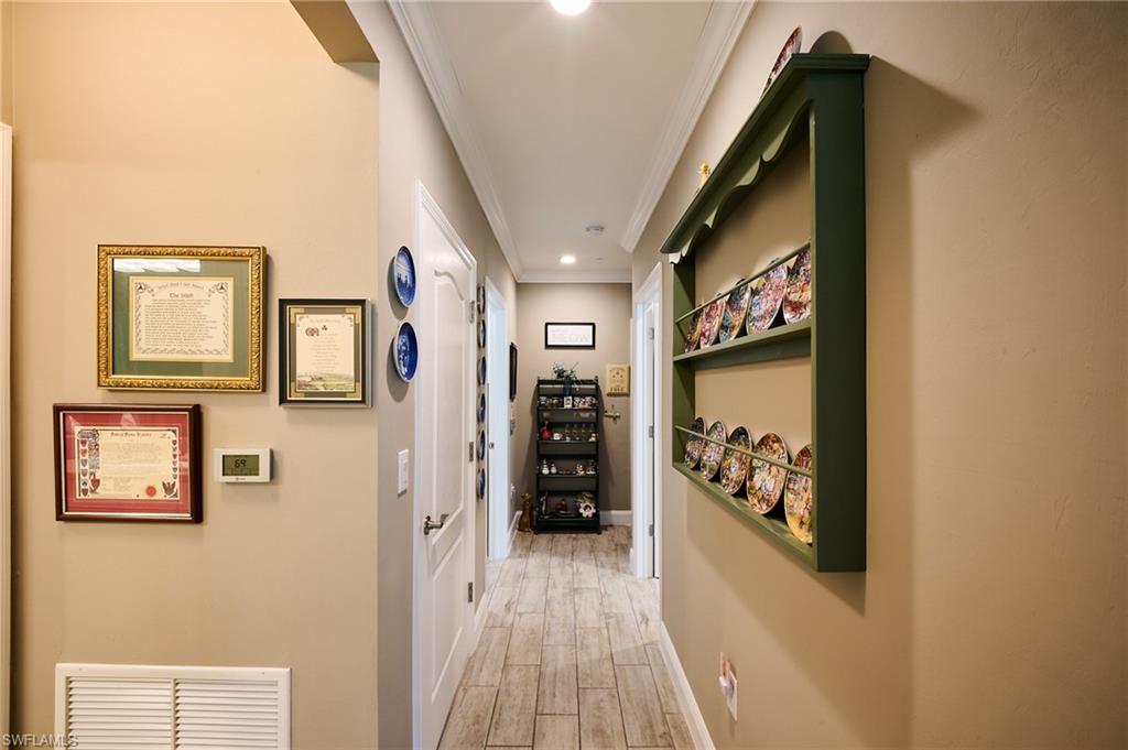 2319 Sawyers Hill Road, Unit 701 Naples, FL 34120 - Photo 16 of 36 a hallway with wooden floor and furniture