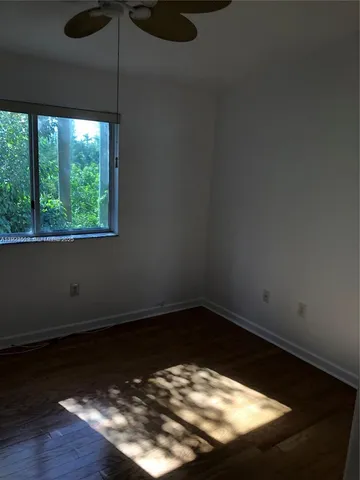 a view of a small space with wooden floor and a window