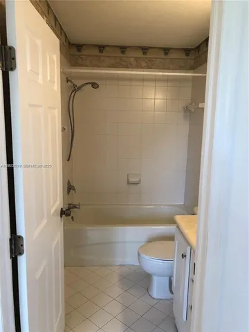 a bathroom with a granite countertop toilet a sink and shower