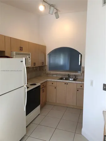a kitchen with cabinets and white stainless steel appliances