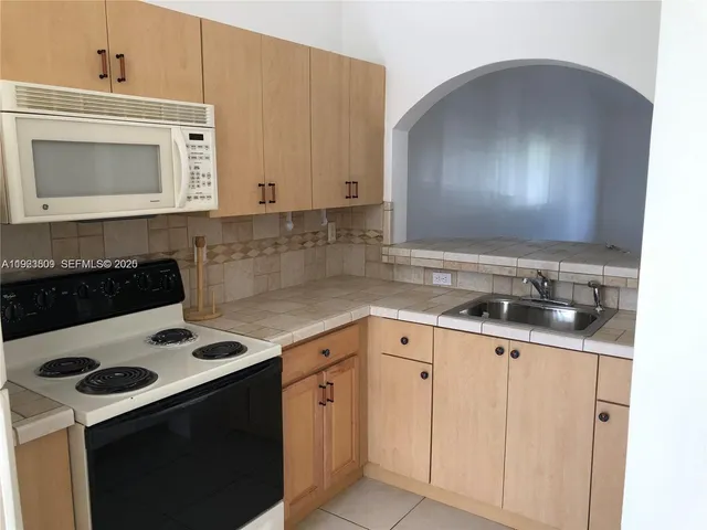 a kitchen with granite countertop cabinets and white appliances