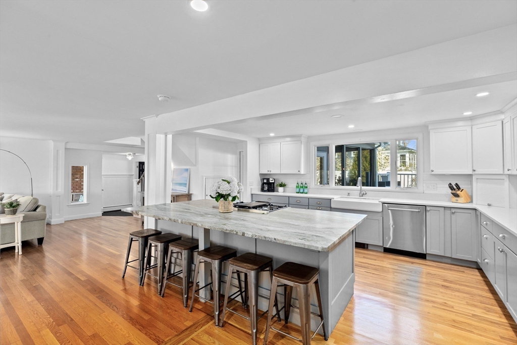 18 Hatherly Road Scituate, MA 02066 - Photo 9 of 42 a kitchen with granite countertop a wooden floor and white cabinets