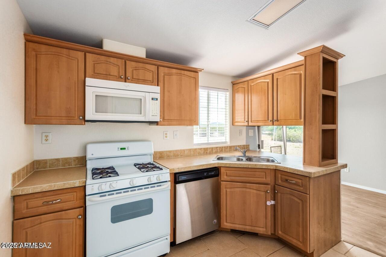 12085 North Musket Road Marana, AZ 85653 - Photo 4 of 13 a kitchen with a sink stove top oven and cabinets
