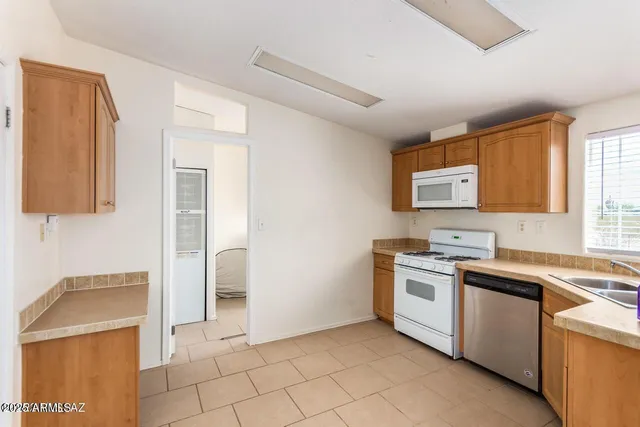 a kitchen with a stove sink and cabinets