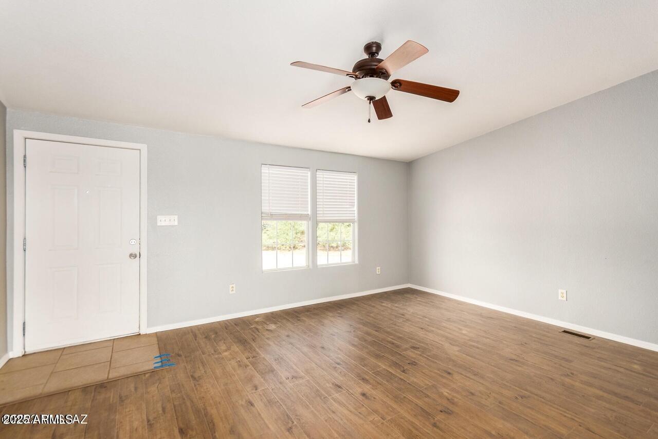 12085 North Musket Road Marana, AZ 85653 - Photo 6 of 13 a view of an empty room with wooden floor and a window
