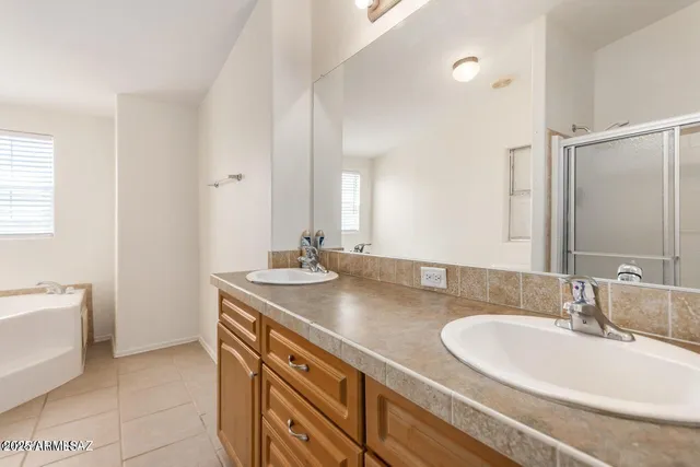 a bathroom with a granite countertop sink a large mirror and a bathtub
