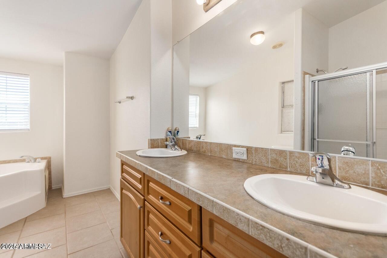 12085 North Musket Road Marana, AZ 85653 - Photo 8 of 13 a bathroom with a granite countertop sink a large mirror and a bathtub