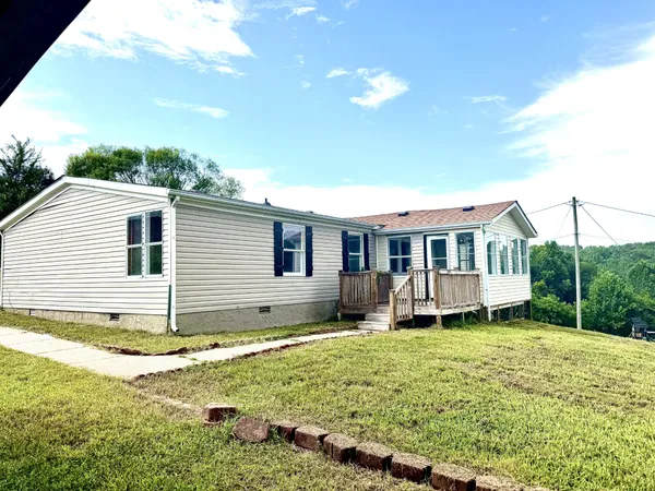 a view of a house with a yard and sitting area