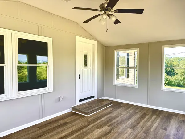 a view of a room with a window and wooden floor