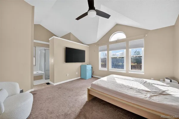 a spacious bedroom with a large bed and a flat screen tv