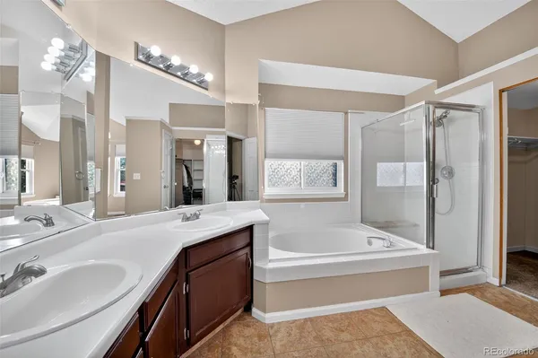 a spacious bathroom with a tub sink shower and mirror