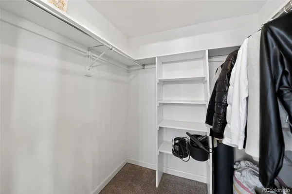 a view of walk in closet with clothes and shoes