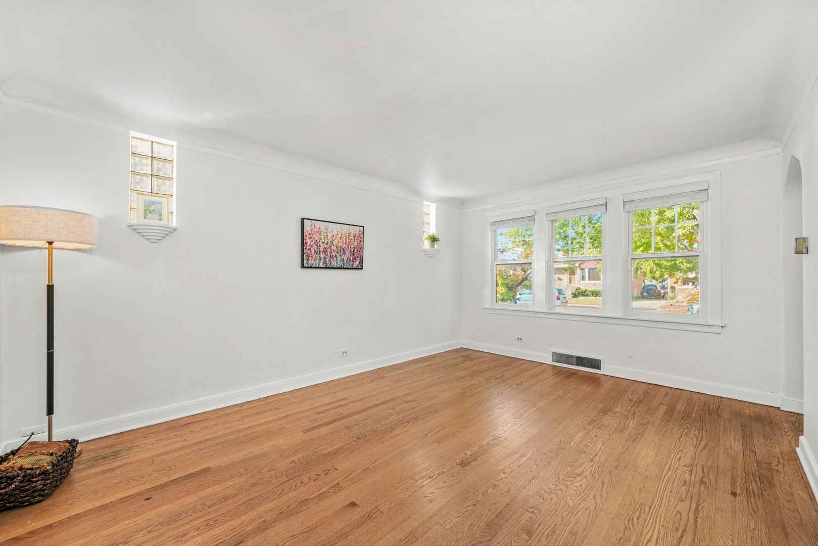 13115 South Escanaba Avenue Chicago, IL 60633 - Photo 2 of 24 an empty room with wooden floor and windows