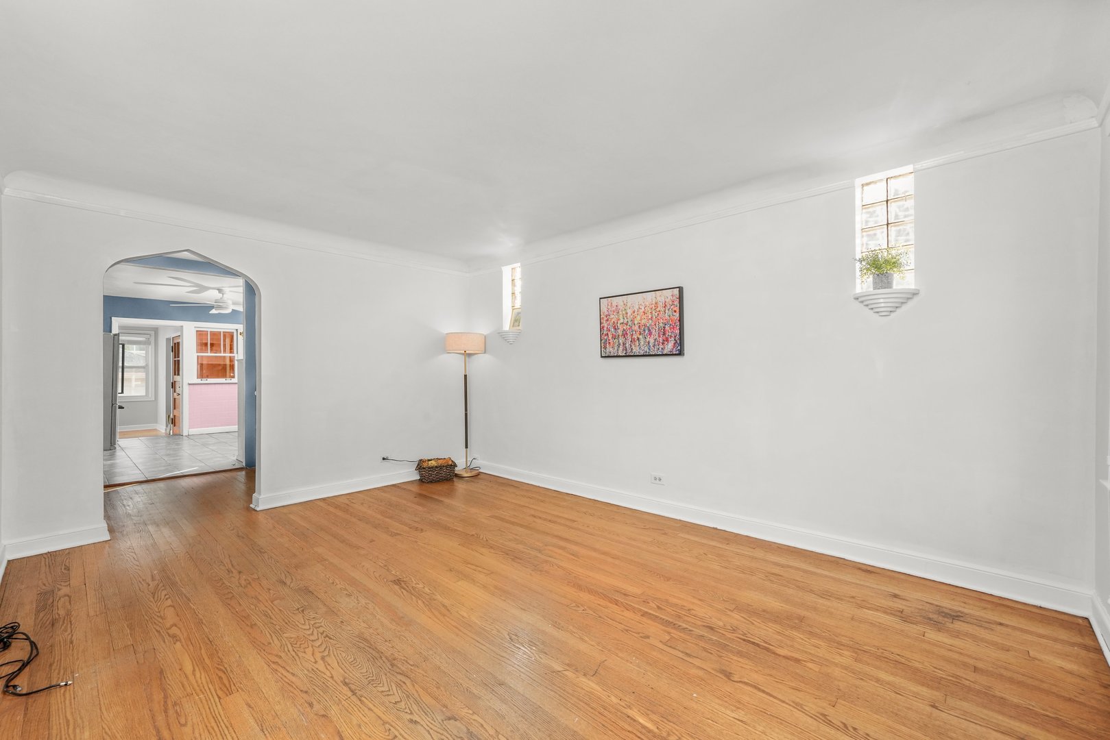13115 South Escanaba Avenue Chicago, IL 60633 - Photo 3 of 24 a view of an empty room with wooden floor and a window