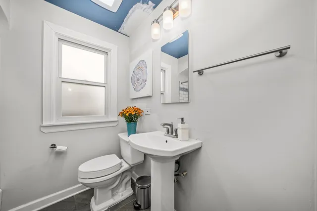 a bathroom with a sink toilet and mirror
