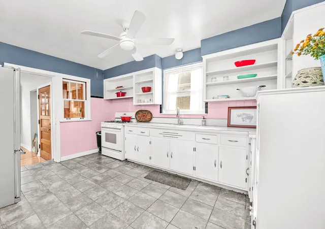 a utility room with cabinets a washer and a large mirror