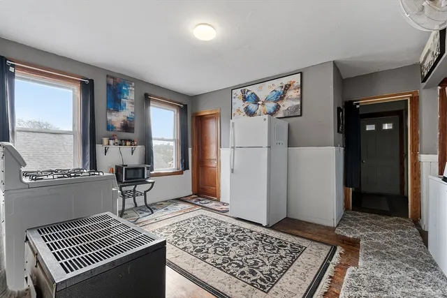 a view of a kitchen with fridge and wooden floor