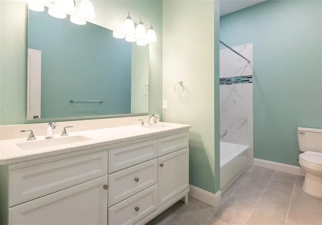 a bathroom with a double vanity sink mirror and toilet