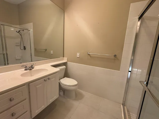 a bathroom with a bathtub shower sink vanity and toilet