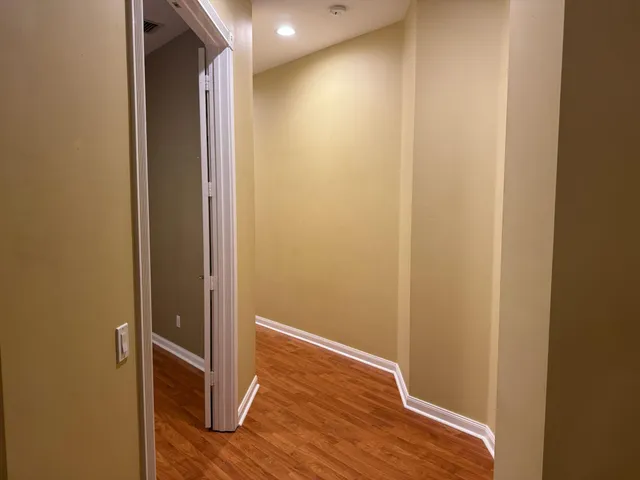 an empty room with wooden floor and a window