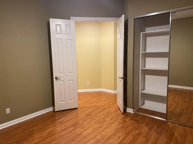 an empty room with wooden floor and entrance