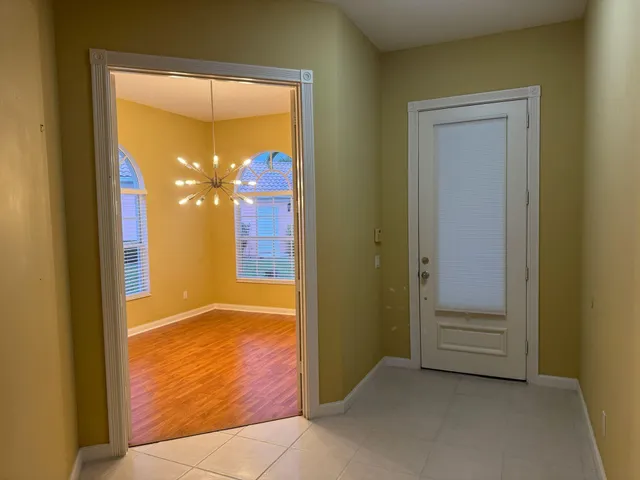 a view of a livingroom with a chandelier and wooden floor