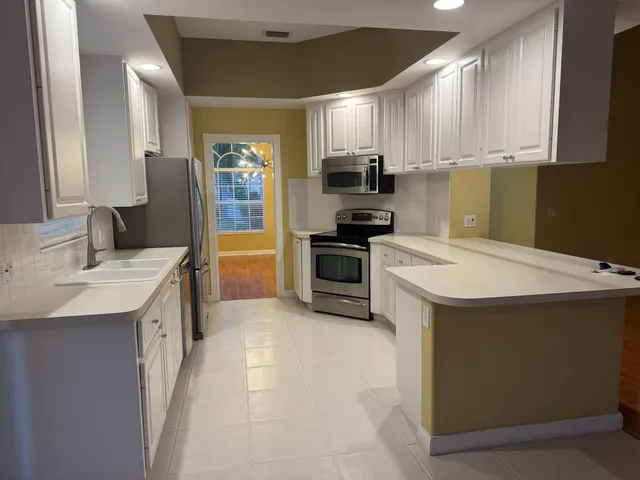 a kitchen with appliances a sink and cabinets