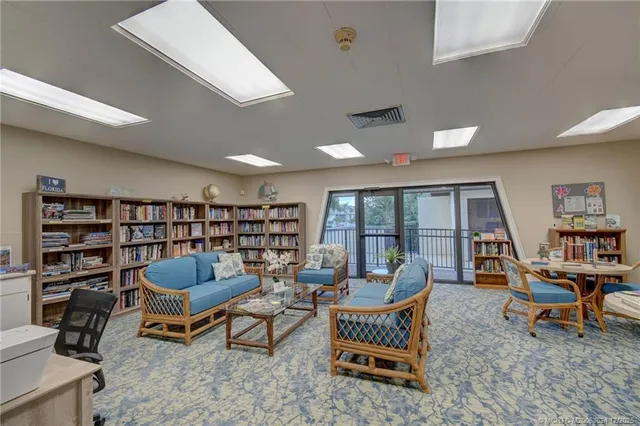 a living room with furniture a rug and a book shelf